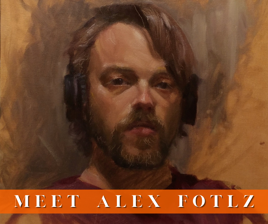 A portrait of Alex Foltz wearing a red tshirt. He has brown shaggy hair and beard.