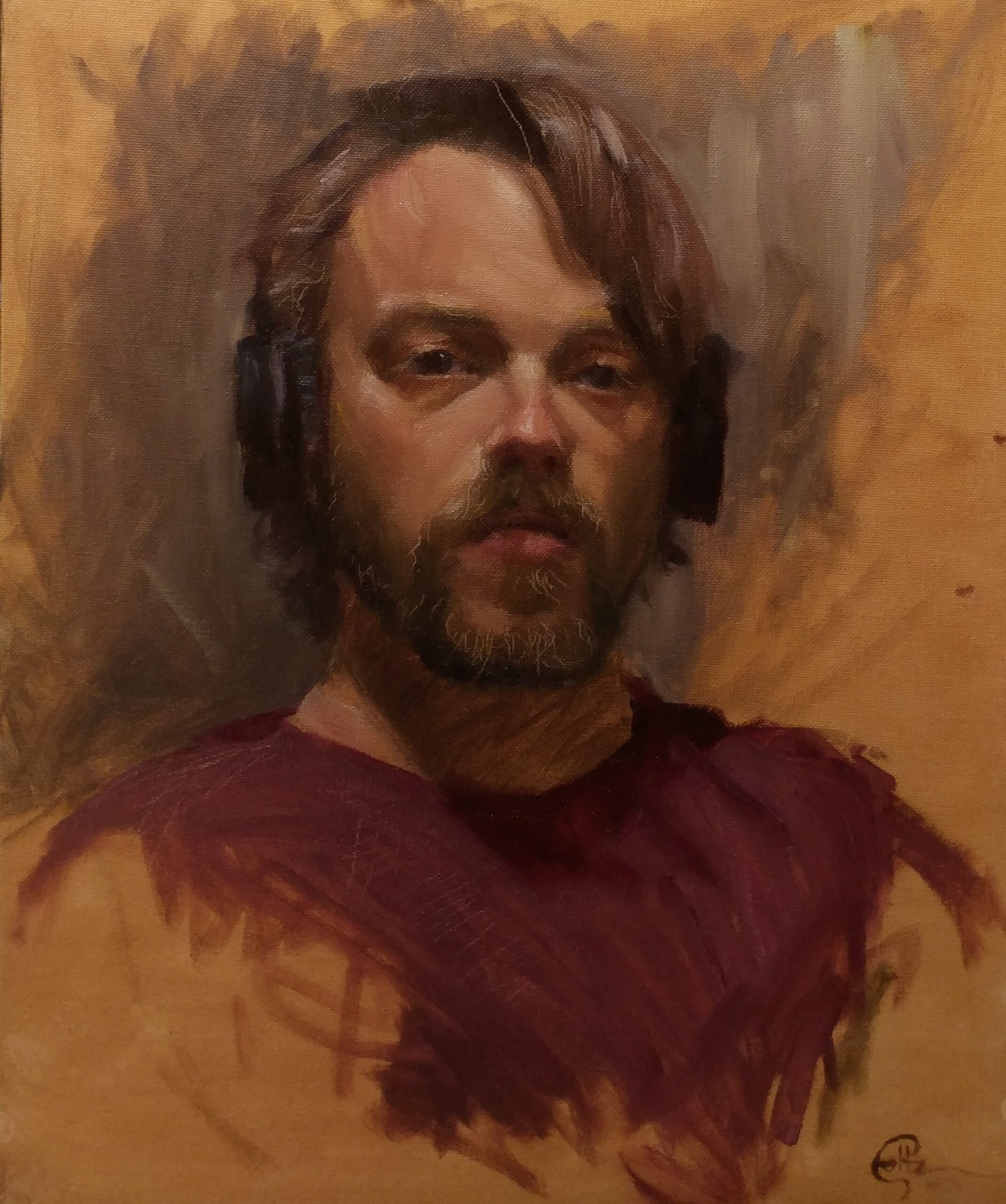 Portrait of Alex Foltz. He is a man with shaggy brown hair and a beard. He is wearing a red shirt.