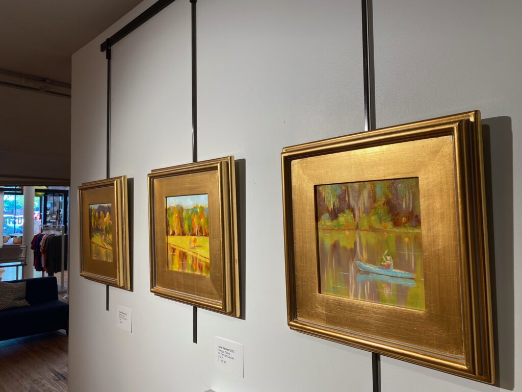 Photo of the inside of the Augusta & Co. Gallery featuring June Klements solo exhibition of oil paintings that portray landscapes and waterways from around Augusta, GA.