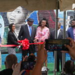 Ribbon cutting in front of the mural