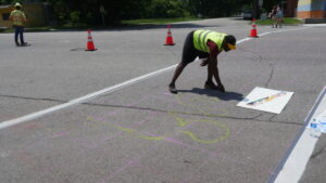 Photo of Ray Sturkey sketching on crosswalk with chalk