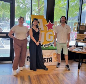 Galadra, Heather, and Cody Cocchi from PIN posing in front of the Augusta sign at Augusta and Co.