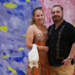 A Caucasian couple posing in front of a back drop