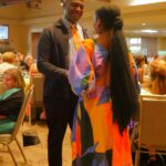 An African American man greeting a African American woman at an event