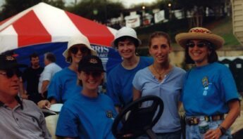 A group of volunteers in blue shirts stand for a photo.