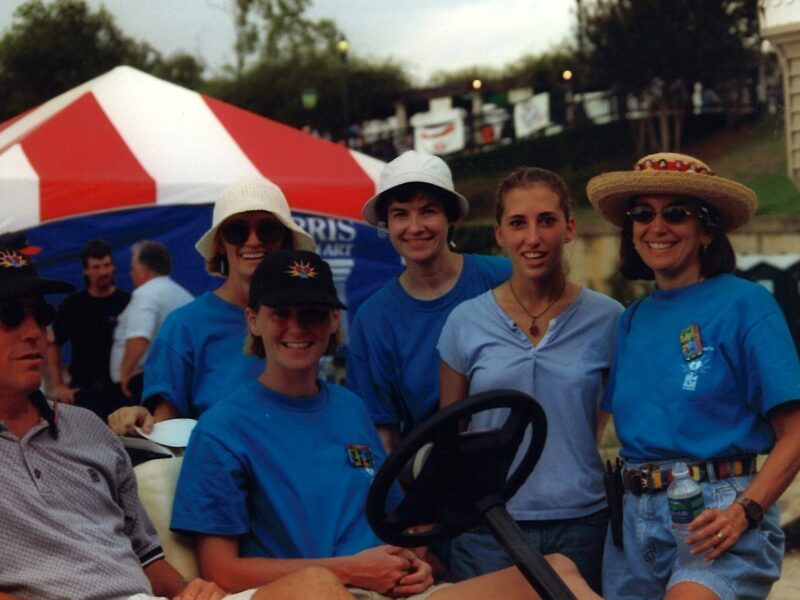 A group of volunteers in blue shirts stand for a photo.