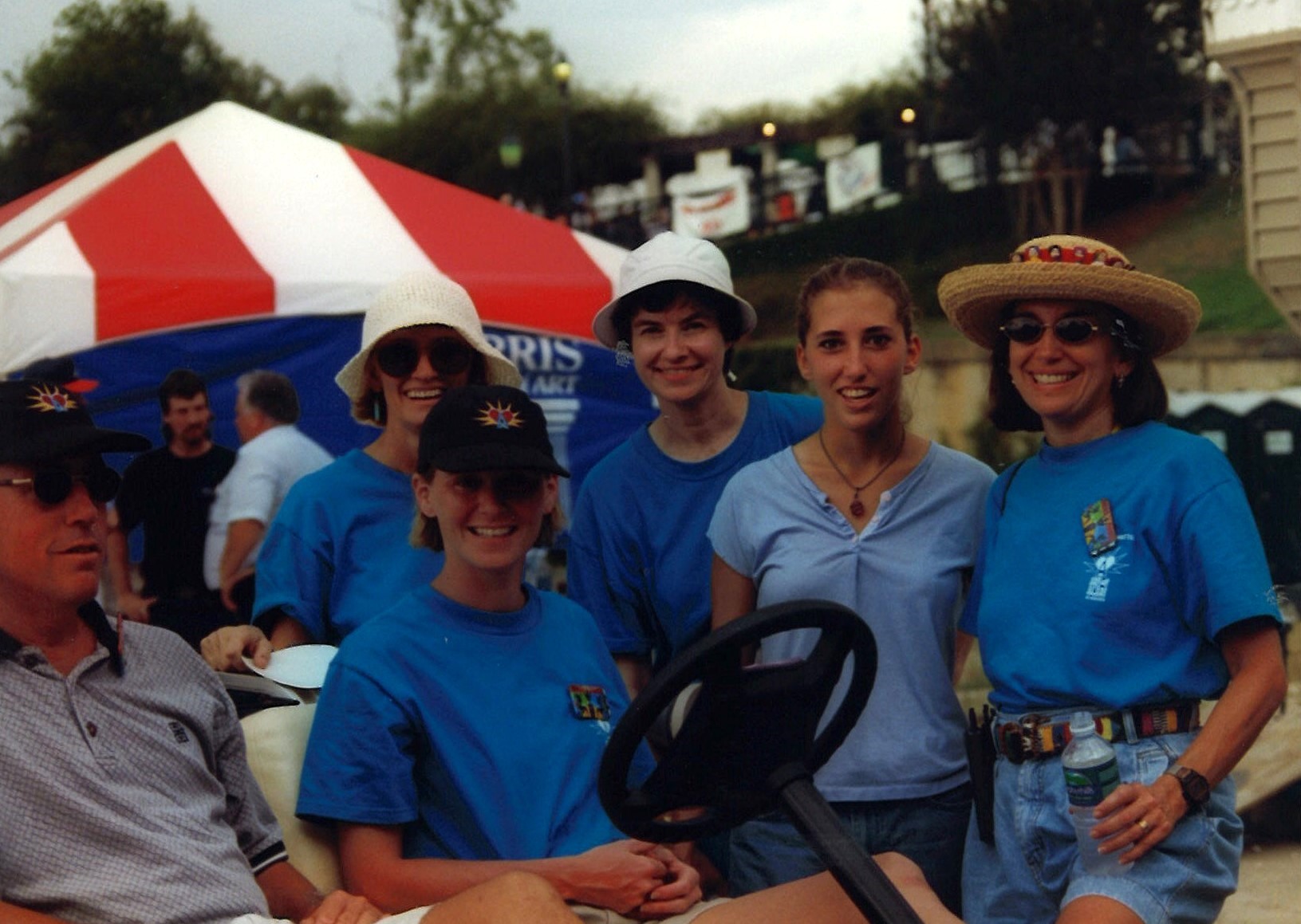 A group of volunteers in blue shirts stand for a photo.