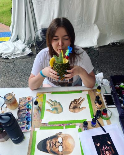 Heather Rene Dunaway sipping a virgin pina colada at Artzilla 10 in 2021