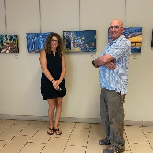 Left to right: Harlem Java House owner Deborah Brawner and artist Michael Meissner standing in front of his oil paintings exhibition "Escapes"